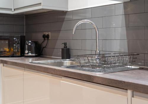 a kitchen counter with a sink and a faucet at The Sapphire Suite - 2BR 2Bath City Centre in Leicester