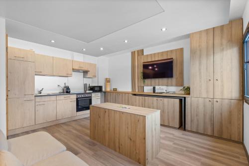 a large kitchen with wooden cabinets and a table at La Capsule - Studio avec vue panoramique in Sion