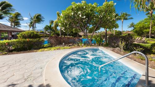 a jacuzzi tub in a yard with trees at SEA GLASS Stunning 3BR KaMilo Home with Heated Pool and Best View in Waikoloa