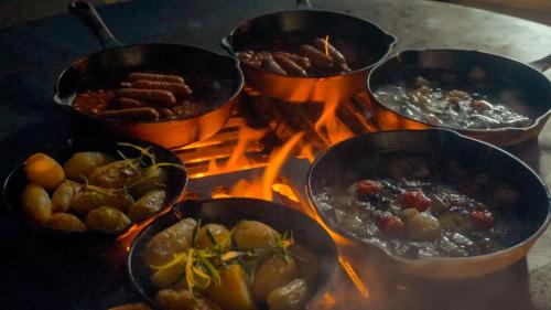 a group of pots of food on top of a fire at RENEST in Kobe