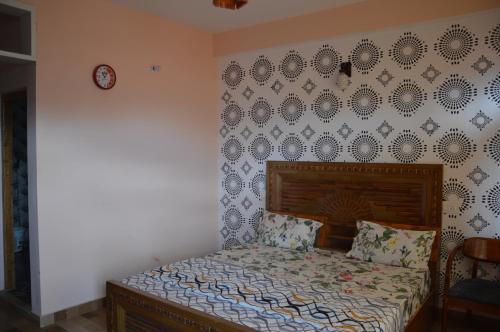 a bedroom with a bed and a wall with a clock at The Banoak Homes Mashobra in Shimla
