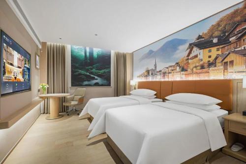une chambre d'hôtel avec deux lits et un tableau au mur dans l'établissement Vienna Classic Hotel Suzhou Likou Furniture Market Metro Station, à Suzhou