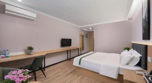 a hotel room with a bed and a television at GreenTree Inn Linxi International Convention Center Express Hotel in Linyi