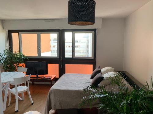 une chambre avec un lit, une table et une télévision dans l'établissement Appartement 2 pièces Paris, à Paris