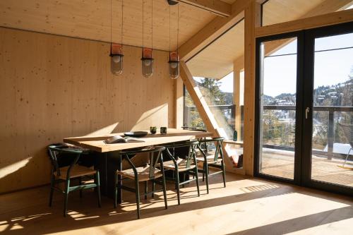 a kitchen with a table and chairs in a house at Naturchalets Turracher Höhe by ALPS RESORTS in Turracher Hohe
