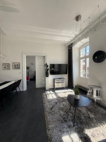a living room with a table and a piano at I'M Apartment PLATINUM premium in Bolesławiec