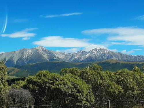 a view of a mountain range with snow covered mountains at Torokiki bach in Springfield