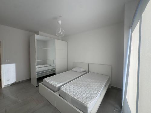 a white bedroom with a bed and a mirror at Marassi El Alamein Luxury Villa مراسي العلمين in El Alamein