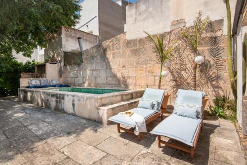 two chairs sitting next to a swimming pool at Ca Na Mon in Ses Salines