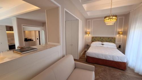 a bedroom with a bed and a couch and a chandelier at Best Western Hotel Rivoli in Rome