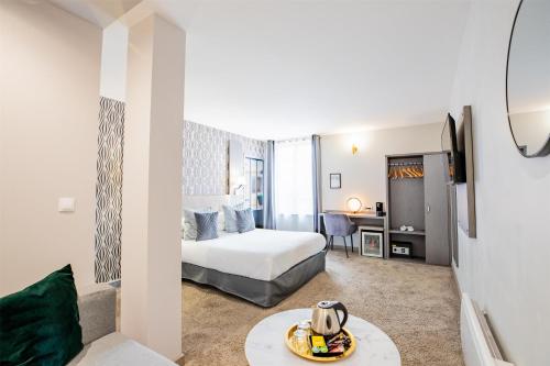 a hotel room with a bed and a table at Best Western Hotel Saint Claude in Péronne