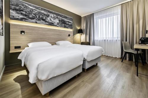 a hotel room with a large bed and a desk at Park Inn by Radisson Vilnius Airport Hotel & Conference Centre in Vilnius
