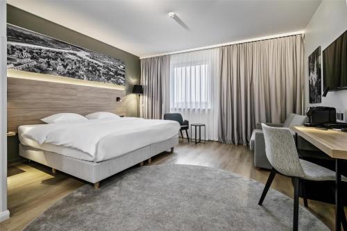 a hotel room with a bed and a desk at Park Inn by Radisson Vilnius Airport Hotel & Conference Centre in Vilnius