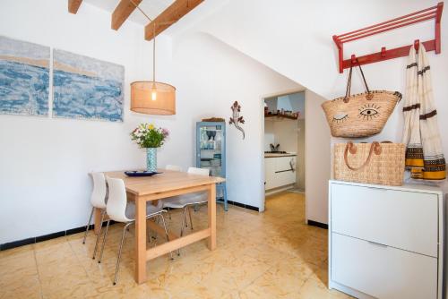 a kitchen and dining room with a wooden table and chairs at Ca Na Mon in Ses Salines