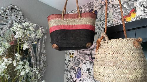 two baskets and a bag hanging from a wall at The Refuge of Happiness in Bouillon