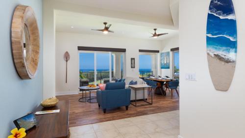 a living room with a blue chair and a dining room at ❤PiH❤ Mauna Kea SunsetsOcean and Golf ViewsOptional Mauna Kea Hotel Privileges in Hapuna Beach