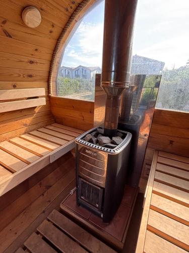 a wood stove in a room with a window at Wood&Stone - Modernes Haus in Seenähe am Tankumsee mit Terrasse, Outdoorküche, Kamin, Homeoffice Bereich & voll ausgestatteter Küche im Naherholungsgebiet in Isenbüttel