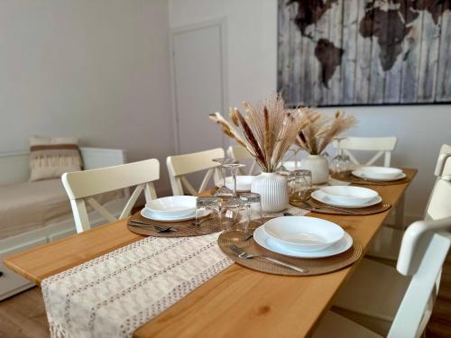 a dining room table with white plates and chairs at Domoi Property Apartment in Pisa