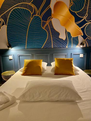 une chambre avec un grand lit avec des oreillers jaunes dans l'établissement Appartement Apollinaire au cœur de Lorient, à Lorient