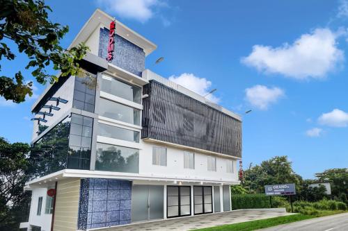 a white building with a sign on the side of it at Grand Parassini by staymax in Parassinikadavu