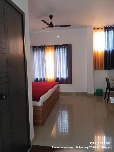 a bedroom with a bed with a red blanket at Grand Parassini by staymax in Parassinikadavu