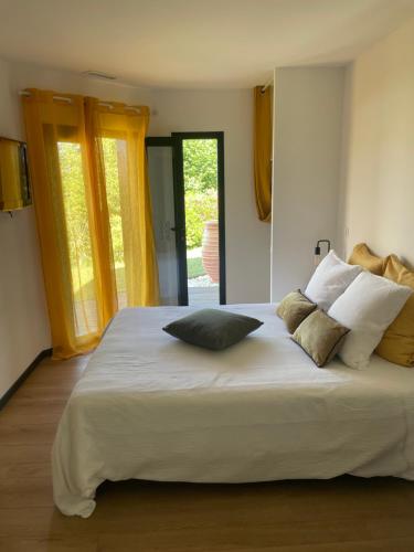 a bedroom with a large white bed with pillows on it at Villa 7 in Martillac