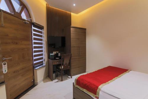 a bedroom with a bed and a desk at Vashishth Guest House in Rishīkesh