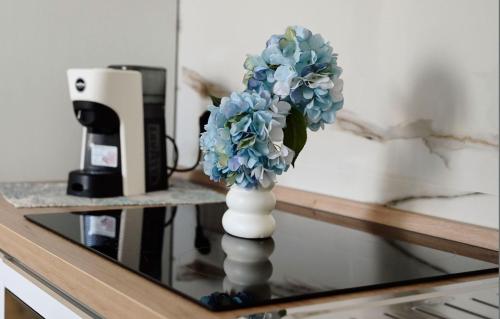 a white vase with blue flowers on a glass table at La Dimora delle Ninfe - Borgo 84 in Pachino