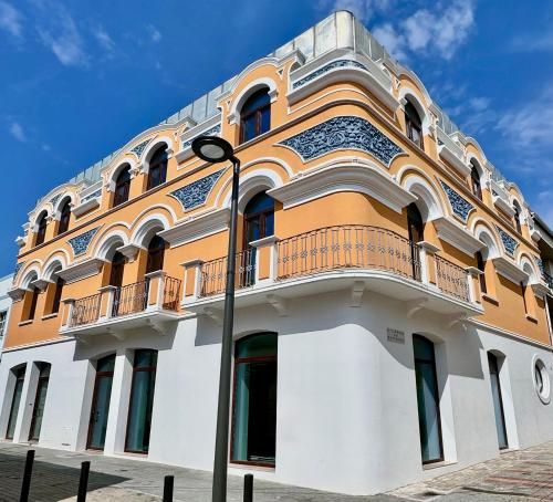 a yellow and white building with a balcony at Glamour Apartments in Figueira da Foz
