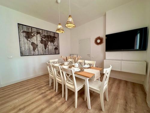 a dining room with a white table and chairs at Domoi Property Apartment in Pisa