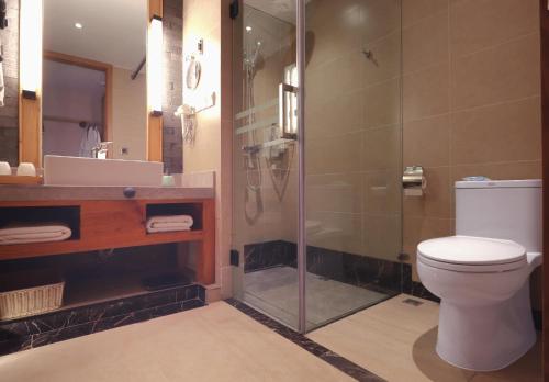 a bathroom with a shower and a toilet and a sink at Mild Spring Boutique Hotel in Huangshan