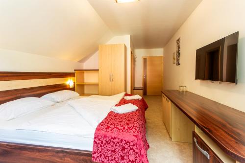 a bedroom with a bed and a flat screen tv at Guest House Hober in Prevalje