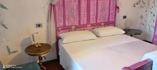 a small bedroom with a bed and two tables at Il Nido del Pettirosso in Borgomanero