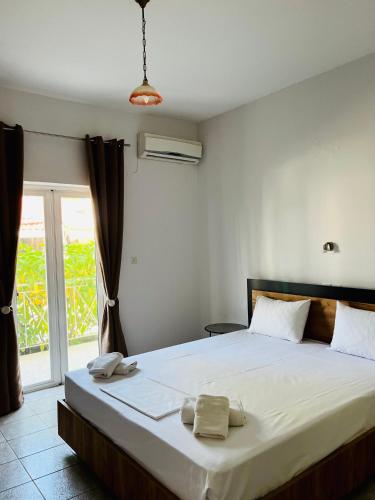 a bedroom with a large bed with towels on it at Hotel Asteras in Ammoudia