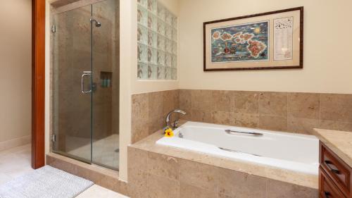 a bathroom with a bath tub and a shower at COCONUT TELEGRAPH Rejuvenating 3BR Villages Home Near Recreation Center in Waikoloa