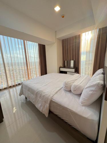 a bedroom with a large bed with white sheets and pillows at 53rd Floor, 2 BR, Netflix, Apt with view by SKY in Batam Center