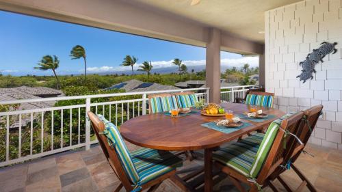 a table and chairs on a balcony with a view of the ocean at SUNSET VILLA Spacious Mauna Lani 3BR Home With Private Beach Club in Waikoloa