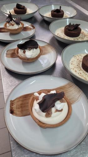 a table topped with white plates with desserts on them at Hôtel la Verriaire - The Originals in La Verrie