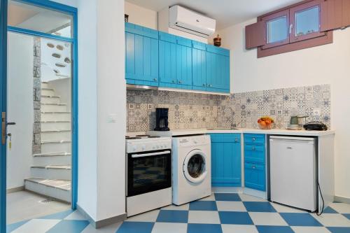 a kitchen with blue cabinets and a washer and dryer at Nicolas House 3 in Rakhídhion