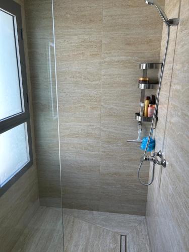 a shower with a glass door in a bathroom at Escapade chic & cosy à Cabo in Cabo Negro