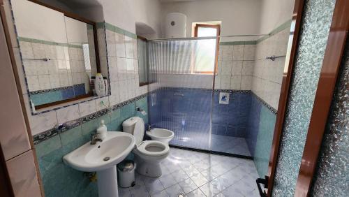 a bathroom with a toilet and a sink and a tub at Kevi City Center Apartments in Përmet