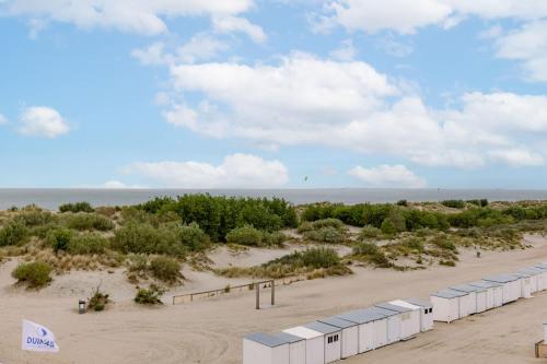 a beach with a row of white containers on it at Huswell - Bright & Stylish Apartment Near Beach with Sea view in Knokke-Heist