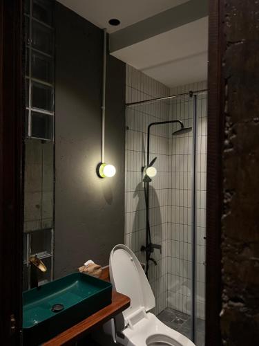 a bathroom with a toilet and a green bath tub at PREEZE boutique stay in Vung Tau
