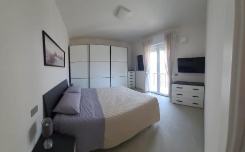 a bedroom with a large bed and a television at Onda Blu in Rimini