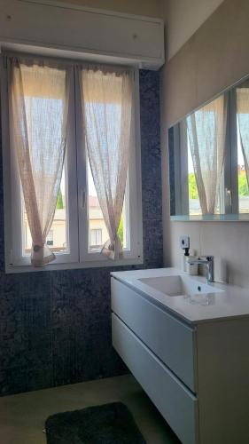 a bathroom with a sink and two windows at Onda Blu in Rimini