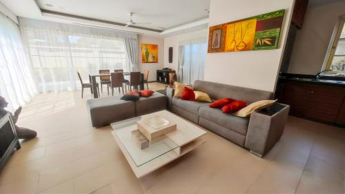 a living room with a couch and a table at The Residence Bantao Villa unit 121 in Bang Tao Beach