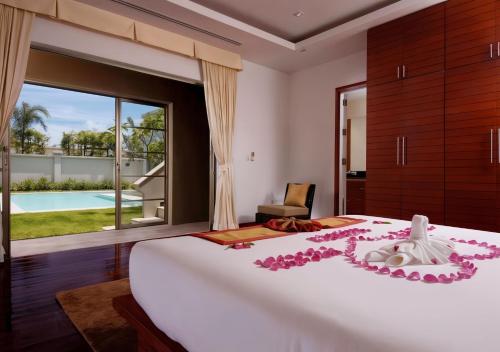 a bedroom with a large bed with pink flowers on it at The Residence Bantao Villa unit 121 in Bang Tao Beach