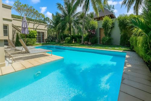 a swimming pool in front of a house at The Residence Bantao Villa unit 121 in Bang Tao Beach