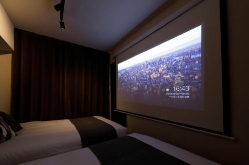 a hotel room with a large projection screen on the wall at サンコート円山ガーデンヒルズ in Sapporo