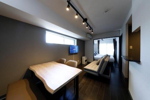 a room with a bed and a living room at サンコート円山ガーデンヒルズ in Sapporo